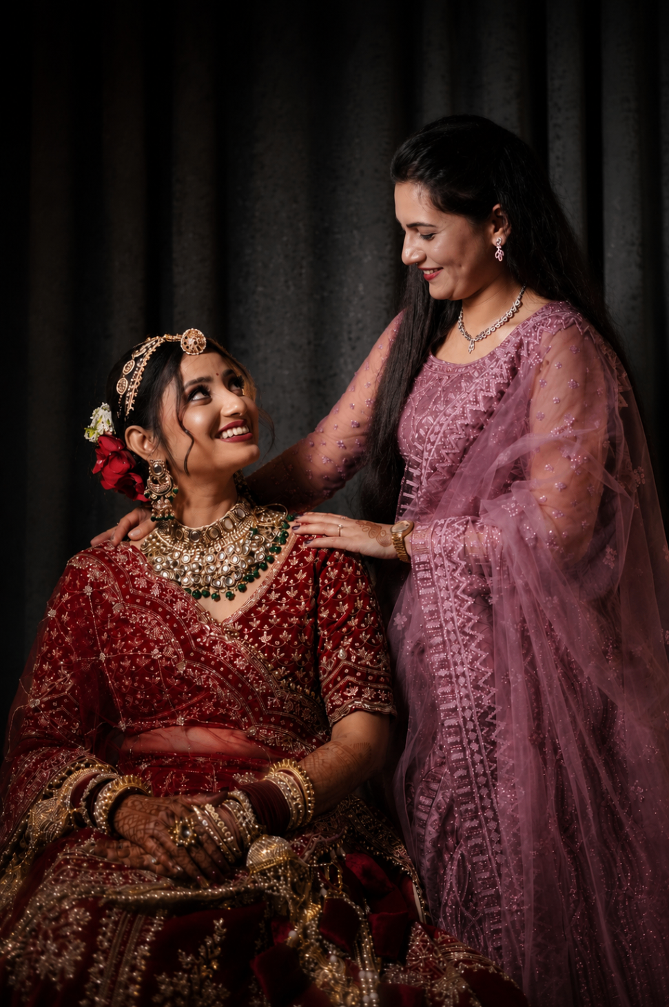 A shared smile between Vaishnavi and her sister during the bridal seating