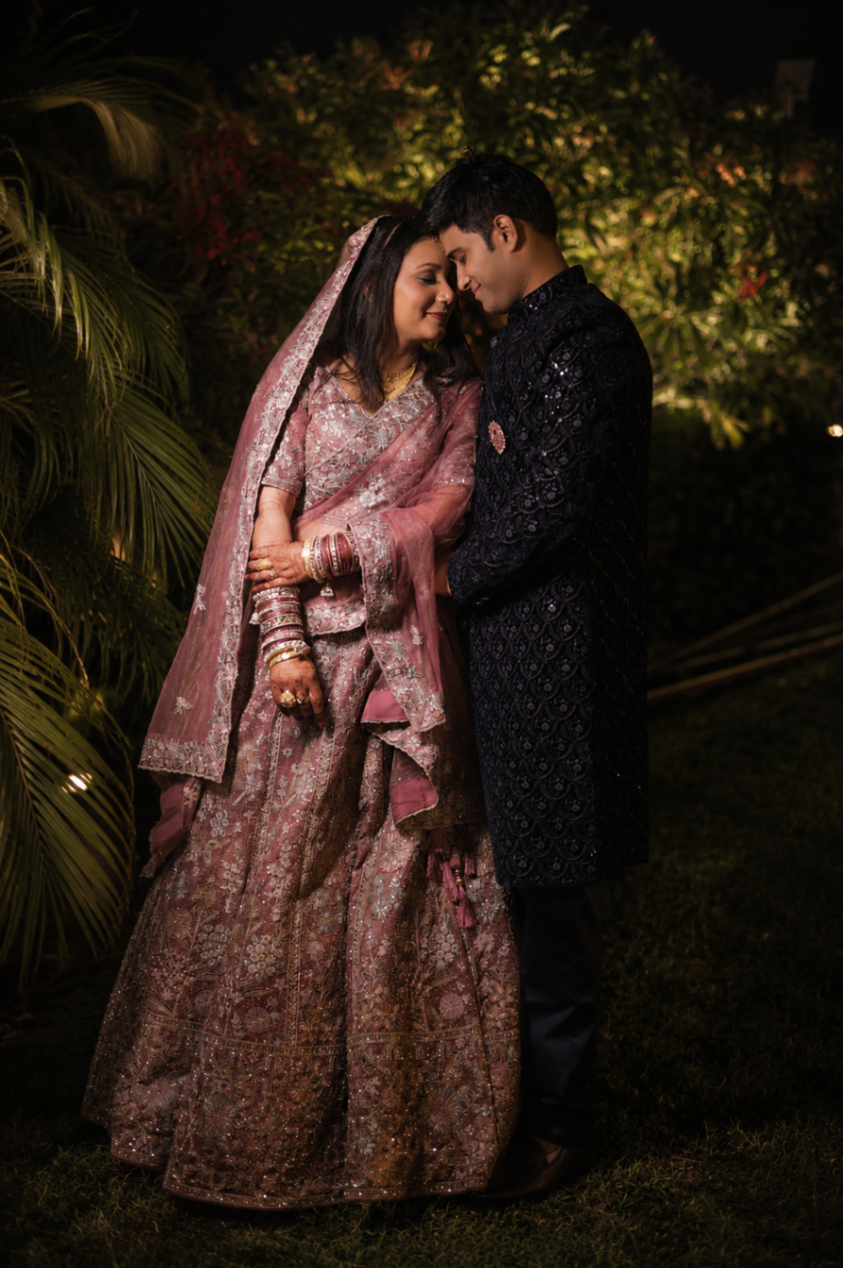 Sakshi and Shubham forehead-to-forehead in the garden after the ceremony