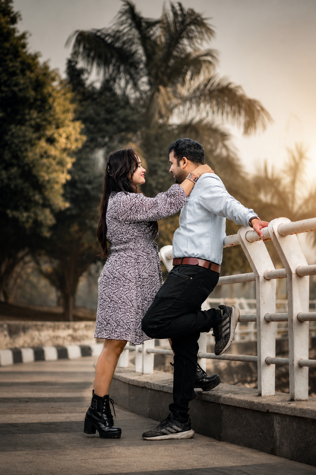 Sarita and Dharmendra sharing a quiet moment on a bridge lined with palms