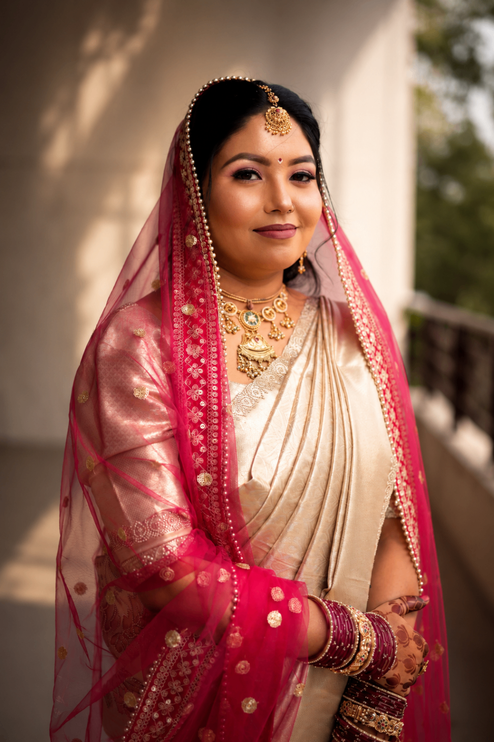 Renu & Gaurav — Renu on the balcony in a pink dupatta and gold saree, Lucknow bridal portrait