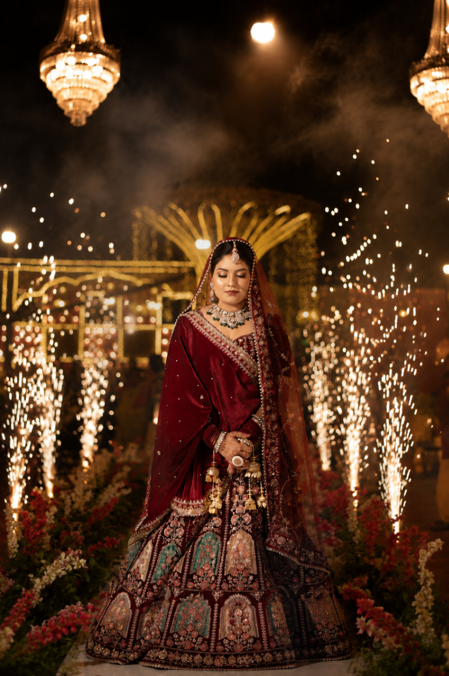 The bridal entry — chandeliers, cold-fire pyrotechnics, Renu walking through the light in maroon velvet